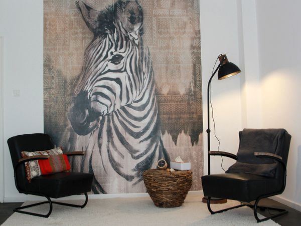 Zwei Stühle für ein Gespräch vor einer Zebra-Tapete 