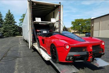 A red sports car being loaded into a trailer.