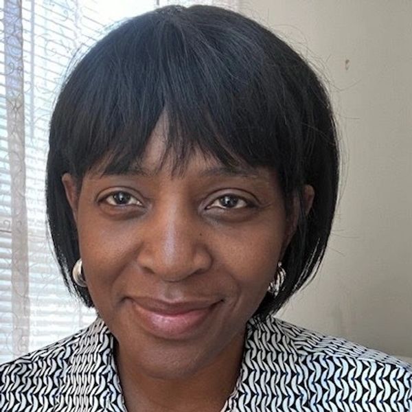 A woman with short black hair smiling gently.