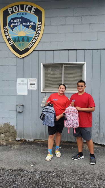 The Quick Pumping kids donating back packs full of back to school goodies