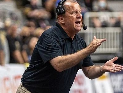Coach passionately directing during a game with headset on.