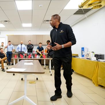 Coach giving a motivational talk to his team in a meeting room.