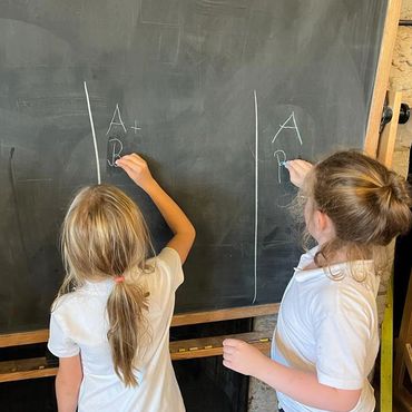 1st Graders writing on the blackboard at school
