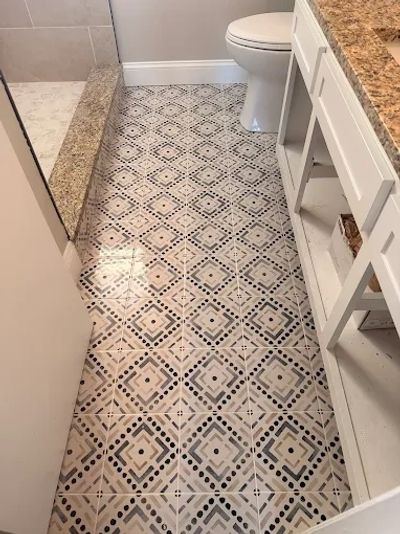 Bathroom floor with geometric patterned tiles.