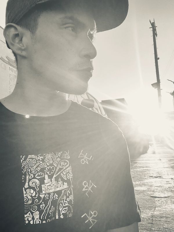 Man in cap with sunflare in background.