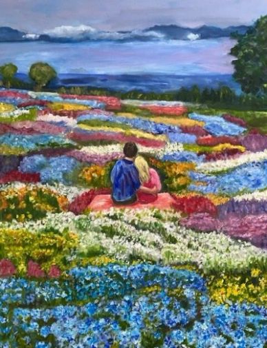 Couple sitting amid vibrant flower fields.