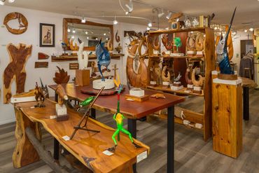 Interior of the gallery filled with handcrafted sculptures, marine artwork, and live-edge wood displ