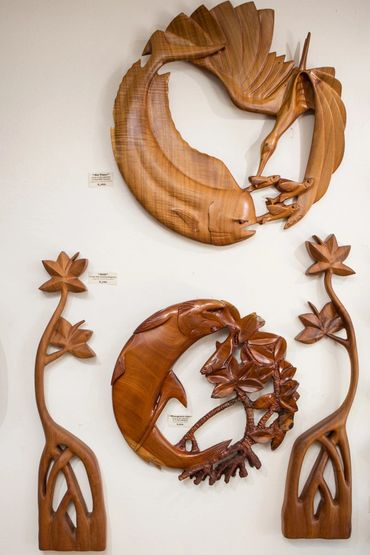 Carved wood marine life sculptures and mangrove-inspired wall art displayed at Wirth Gallery.