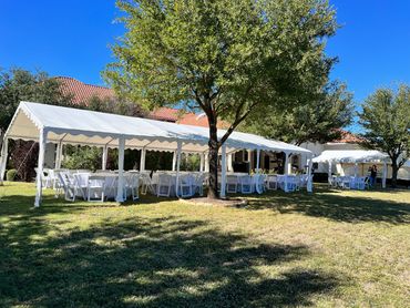 Tent table and chair rental setup for outdoor graduation