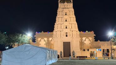 Night view of a decorated temple with tent in front.