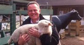A senior fundraising consultant holding a lamb