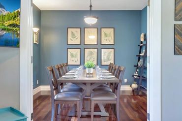 Elegant dining room with blue walls and wooden table set for twelve.