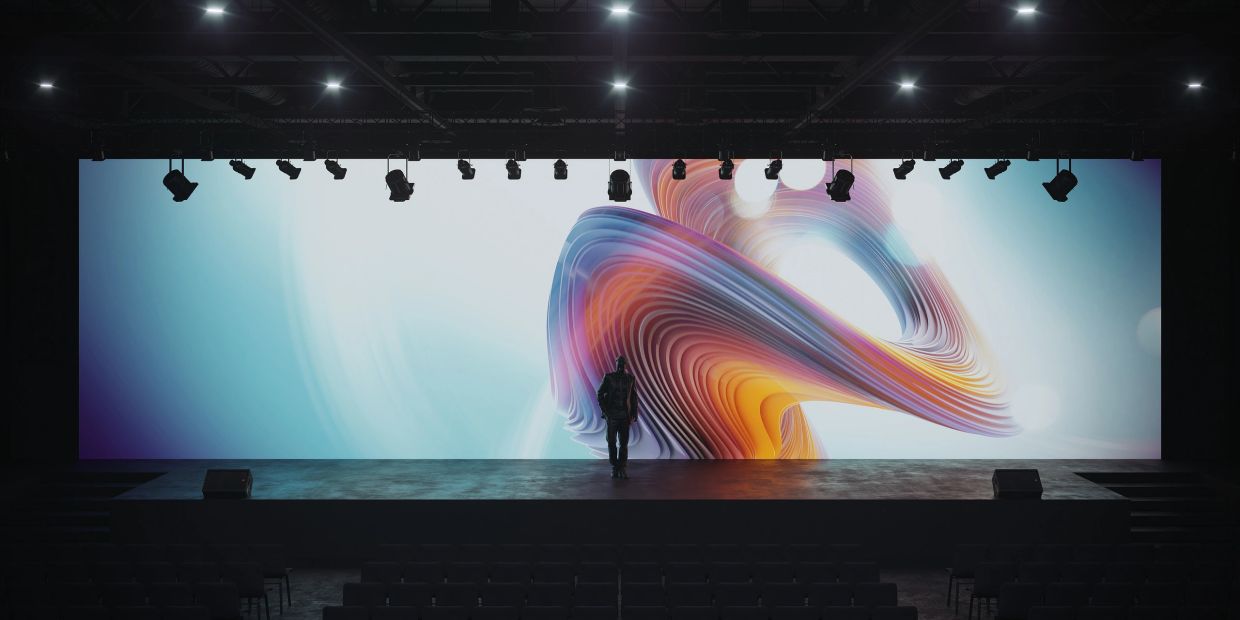 Conference stage with a man that appears to be walking out of the screen. Bring your vision to life!