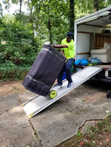 Local movers near Atlanta, GA unloading dresser from truck at customers home in Dekalb County.