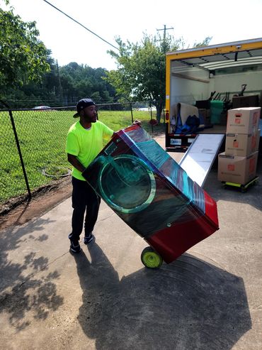 Mover loading red samsung front load washer into storage in Mableton, GA