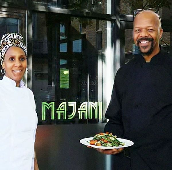Two chefs smiling outside a restaurant named Majani.