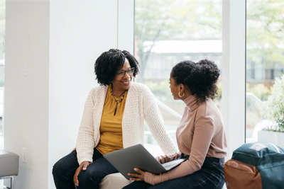 Two women having a conversation indoors.