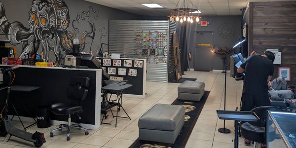 Tattoo studio interior with artist at work.