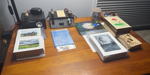 Art prints and supplies neatly organized on a wooden table.