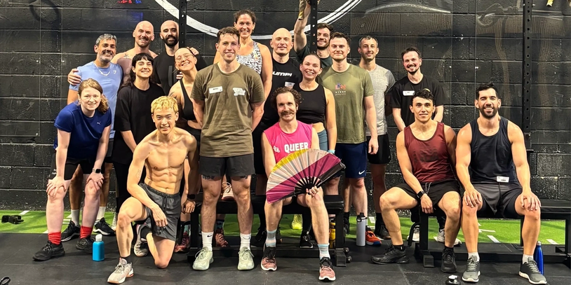 Group of people posing at a gym.