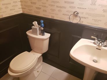 A small bathroom with a toilet, sink, and motivational quote wallpaper.