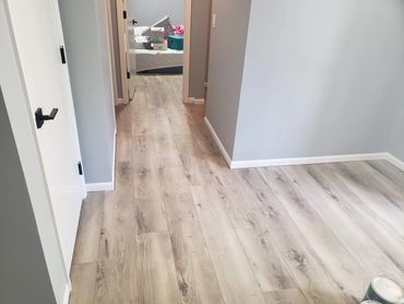Newly installed light wood flooring in a modern hallway.