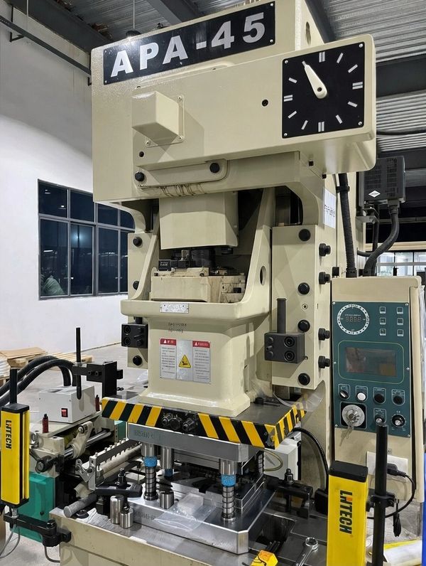 Industrial APA-45 stamping press machine in a factory setting.