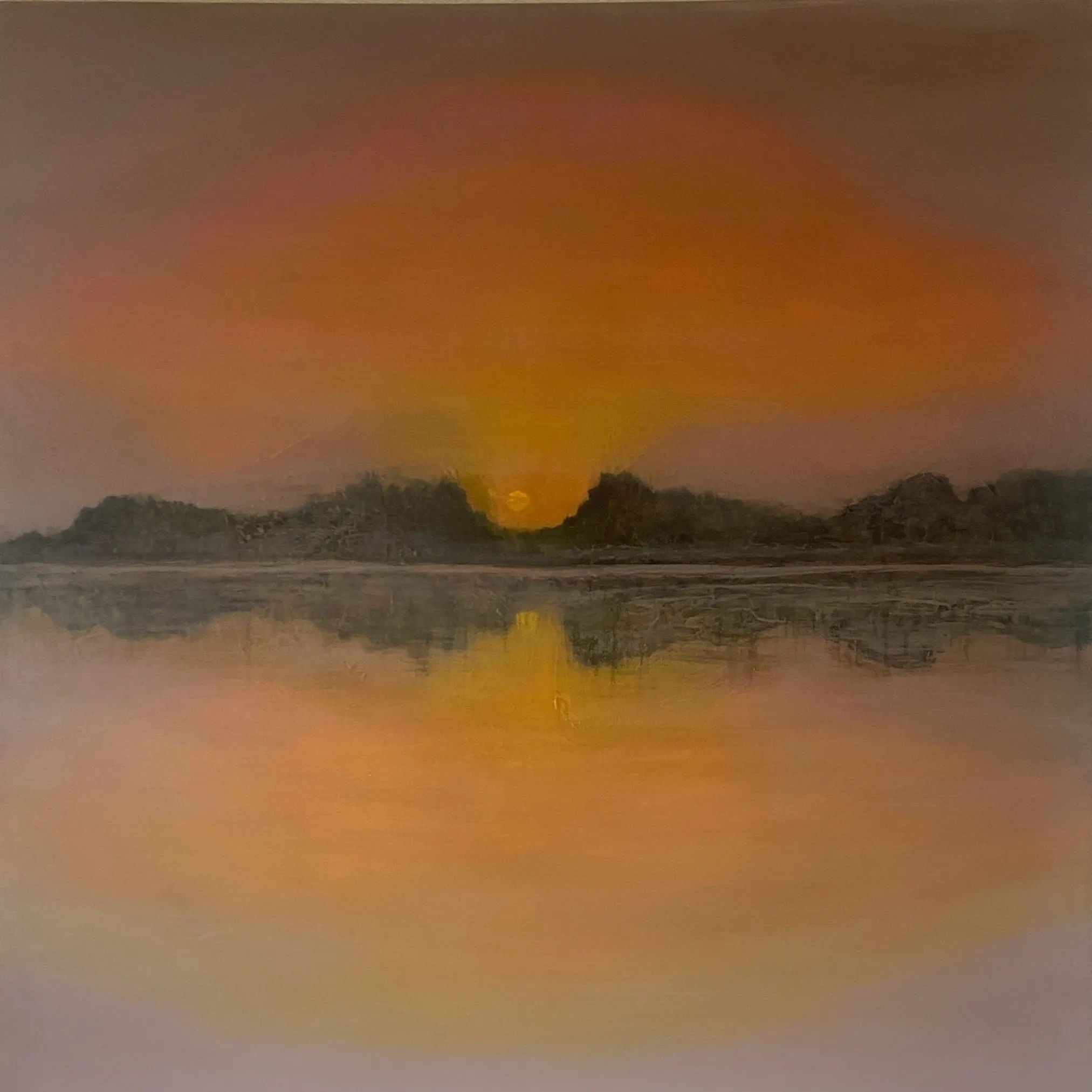 Atardecer dorado con reflejo en el agua y montañas oscuras.