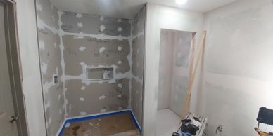 A room under construction with drywall installation in progress.