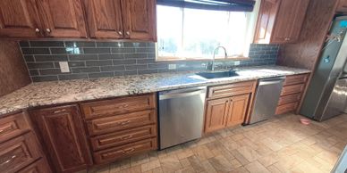 Modern kitchen with granite countertops and wooden cabinets.
