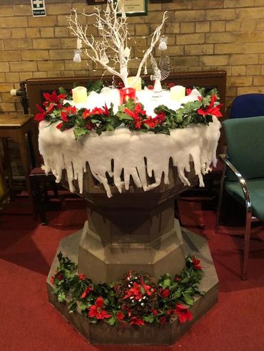Chrsitmas decoratioins on the font at St Chad Hopwas