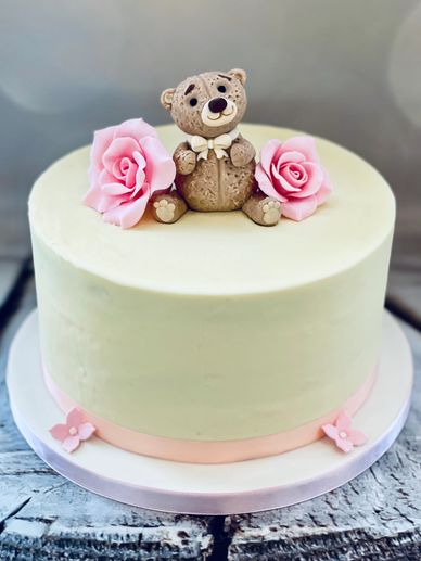 Ivory buttercream  pretty baby shower cake with teddy bear and pink roses