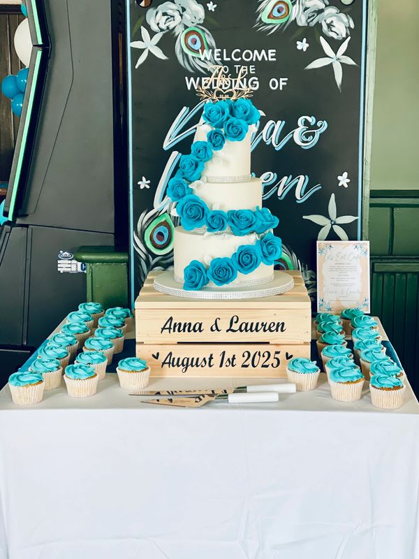3 tier white fondant wedding cake with Cascading handmade teal sugar roses and matching cupcakes