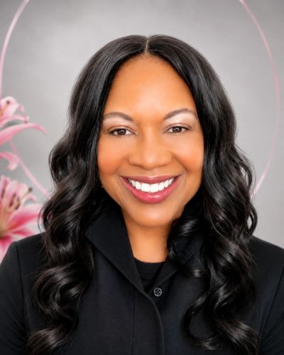 Smiling woman with long wavy hair in black outfit.