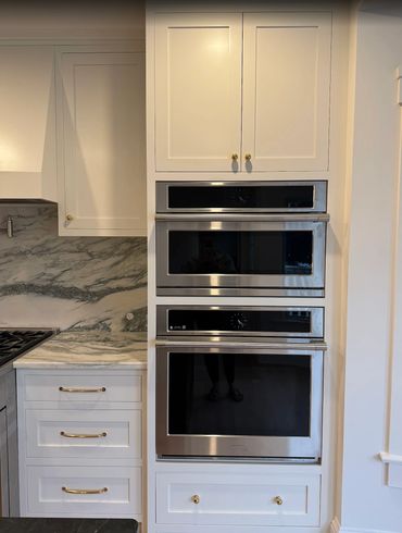 Electrical installation for a high-end kitchen featuring built-in wall ovens and appliances.