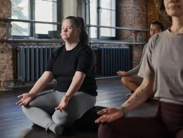 People meditating indoors in a calm environment.