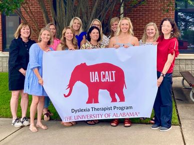 Group holding UA CALT Dyslexia Therapist Program banner.