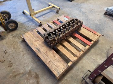 Engine cylinder head on a wooden pallet.