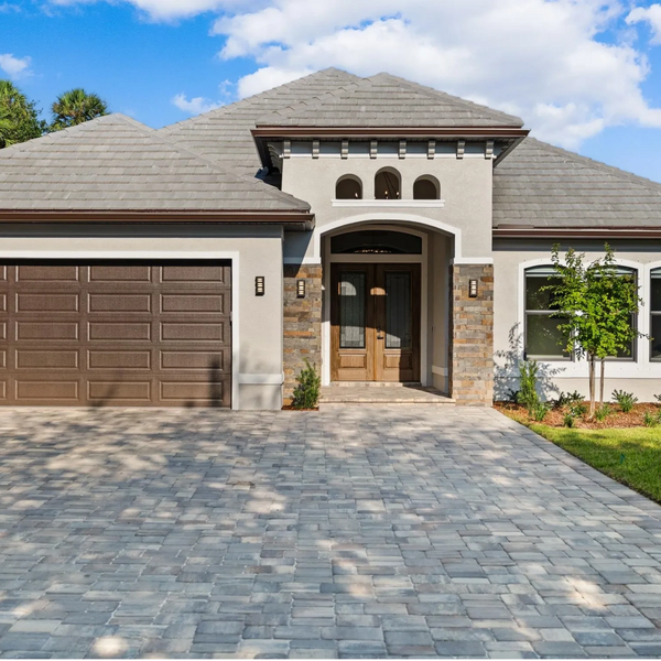 Modern single-story house with a large driveway and two-car garage.