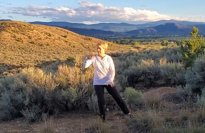 Christine Bhe, certified Tai Chi and Qigong Instructor with hills and blue sky.