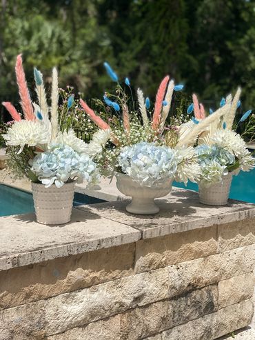 trio of ceramic vases with light blue, white and pink flowers 