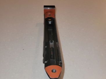 A close-up view of a utility knife with an orange and black handle.