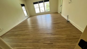 Empty room with wooden floor and windows.