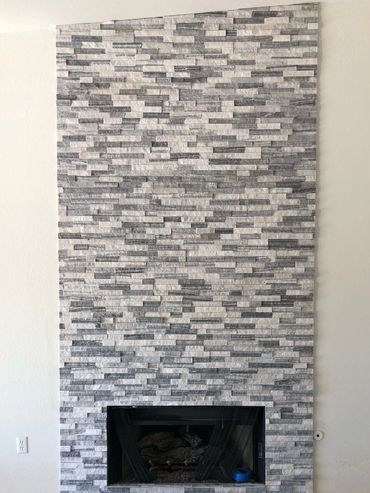 Floor-to-ceiling, splitface stacked stone fireplace surround