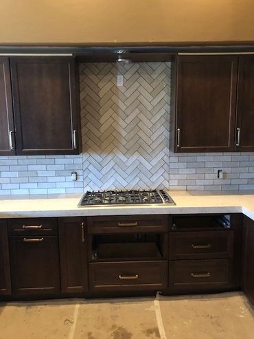 Modern kitchen with dark wood cabinets and white subway tile backsplash.