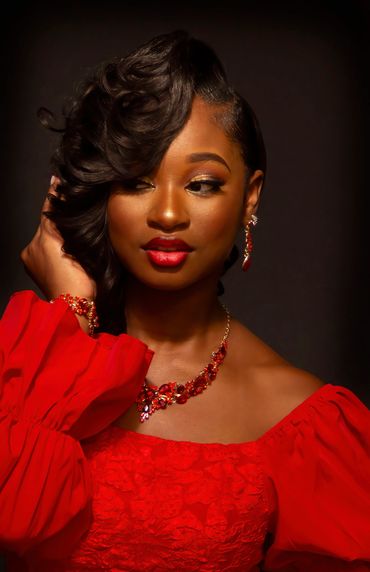 Elegant woman in a red dress with matching jewelry.
