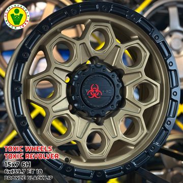 Bronze and black off-road wheel with unique design.