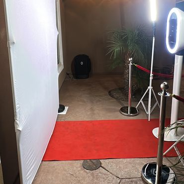 Red carpet setup with photo backdrop and ring light outdoors at night.
