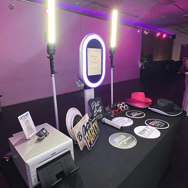 Photo booth setup with lights, props, and a printer for a 30th birthday party.
