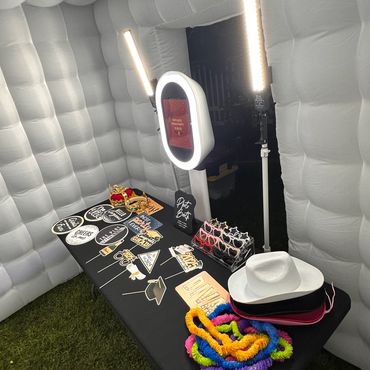A photo booth setup with props and lighting inside an inflatable booth.